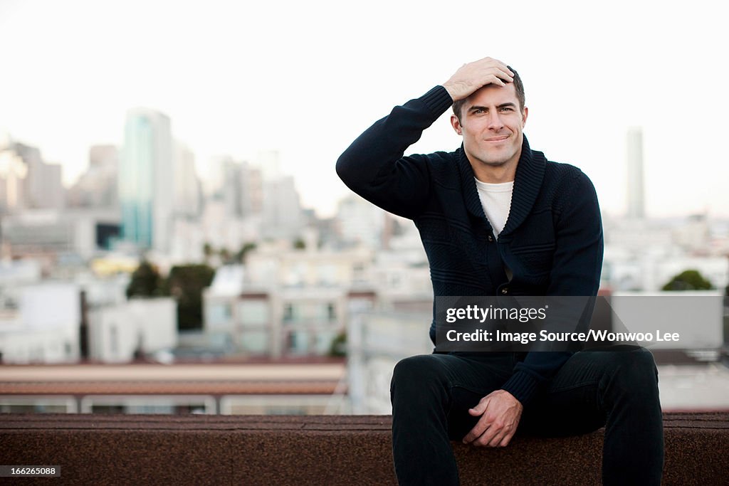 Man sitting on urban balcony