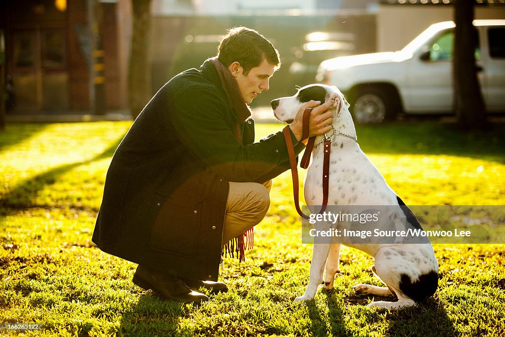 Man petting dog in park