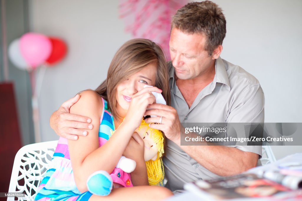 Father comforting teenage daughter
