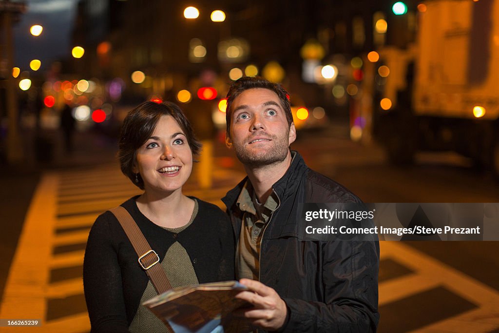 Couple reading city map at night
