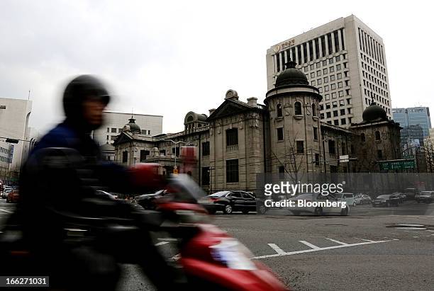 Traffic moves past the Bank of Korea headquarters in Seoul, South Korea, on Thursday, April 11, 2013. The Bank of Korea held borrowing costs...
