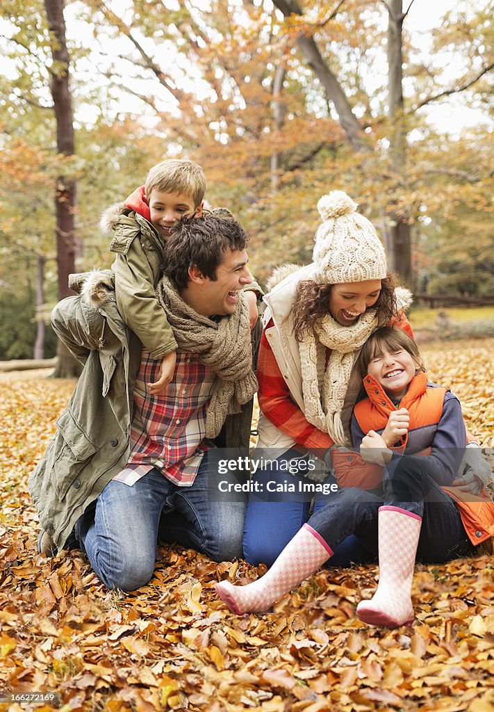 Family playing together in autumn leaves