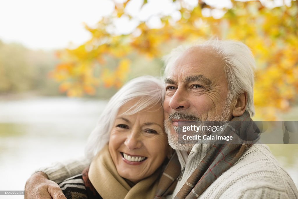 Older couple hugging in park