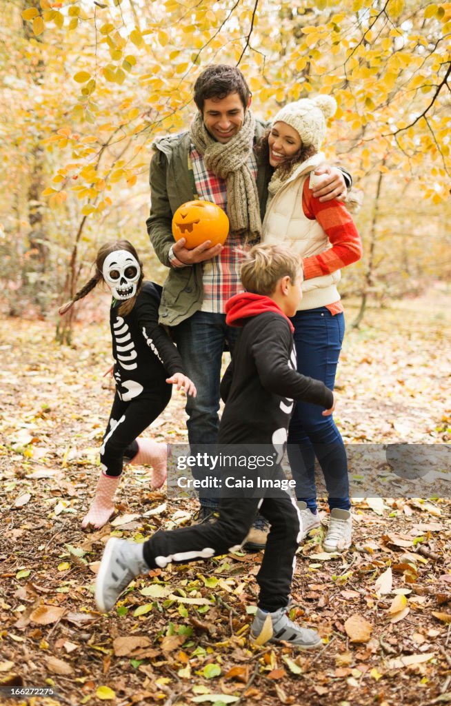 Coppia con bambini in costumi di scheletro nel parco