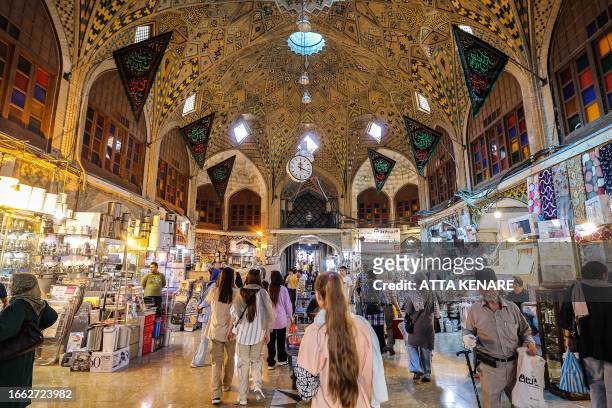 People shop at the Grand Bazaar in Tehran on September 5, 2023. A year after the death of Mahsa Amini sparked unrest across Iran, the issue of the...