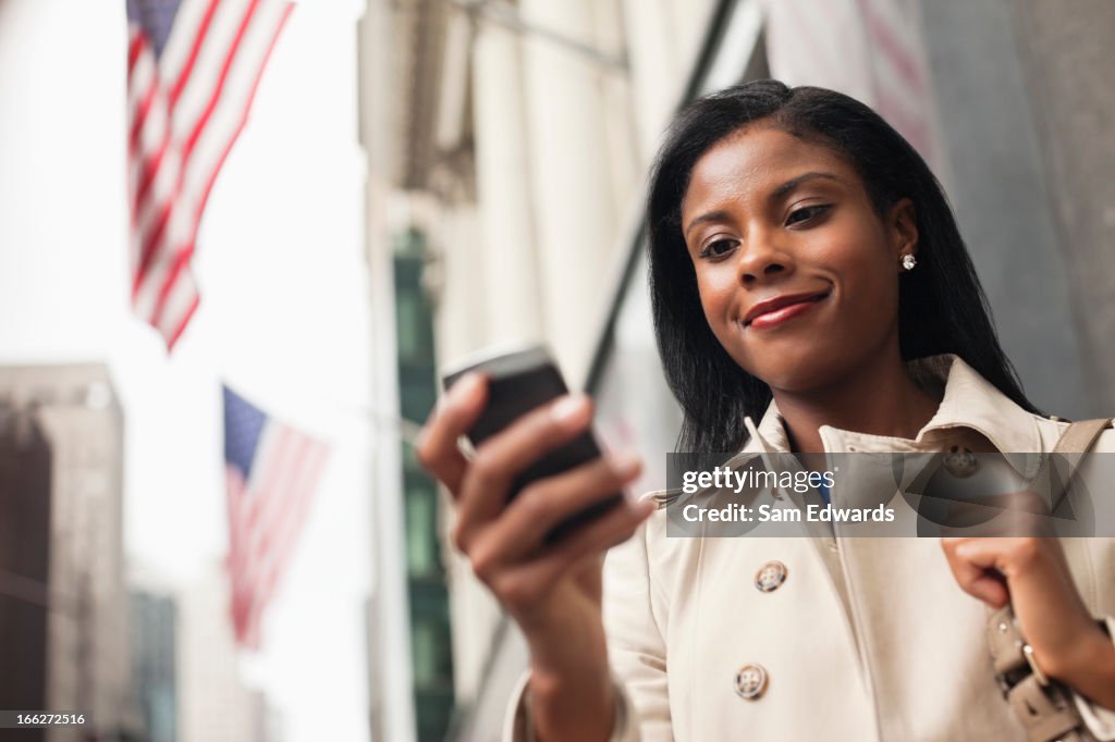 Businesswoman using cell phone on city street