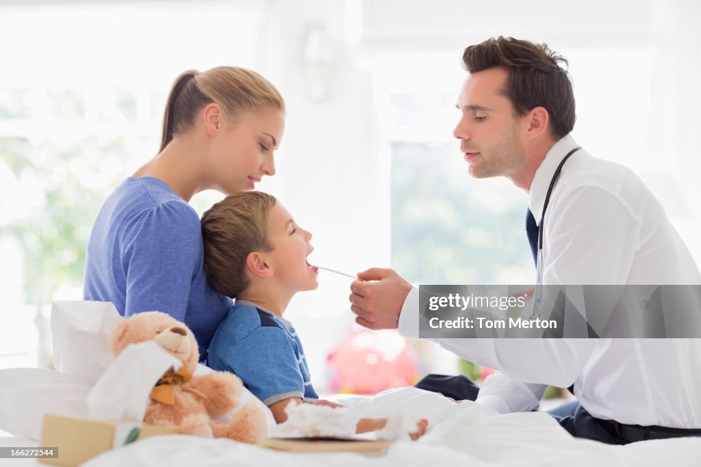 Doctor taking son's temperature