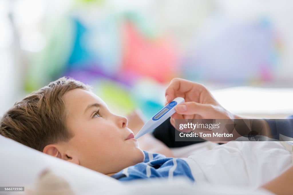 Figlio di madre prendendo la temperatura