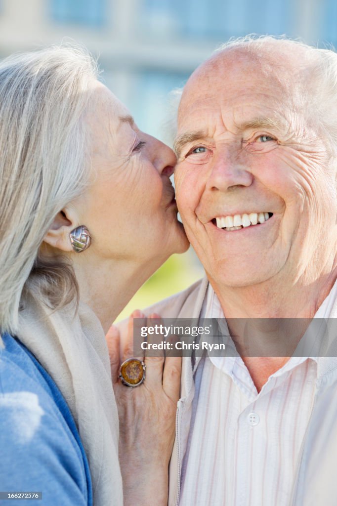 Smiling older couple kissing outdoors