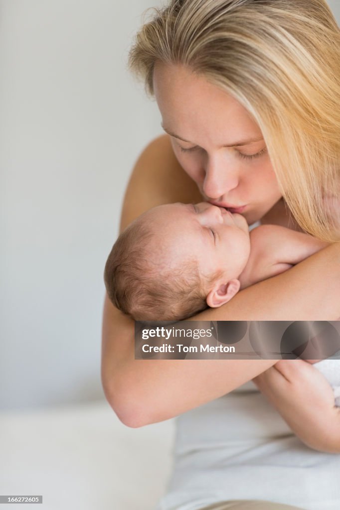 Mother kissing newborn baby