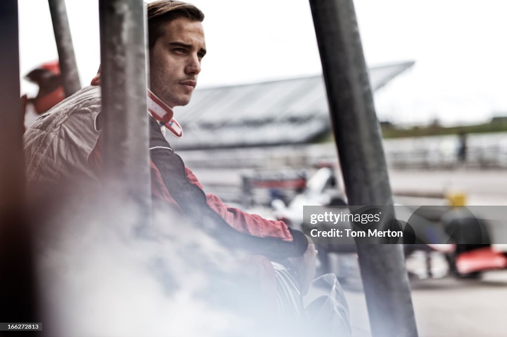 Racer standing on sidelines on track