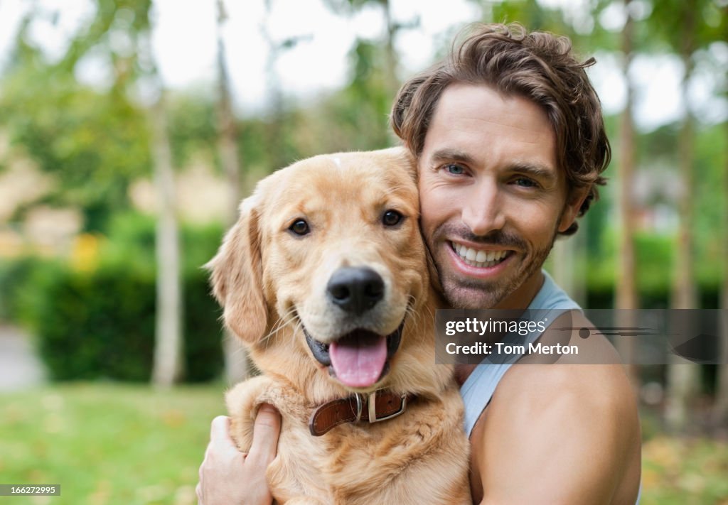 Smiling man petting dog outdoors