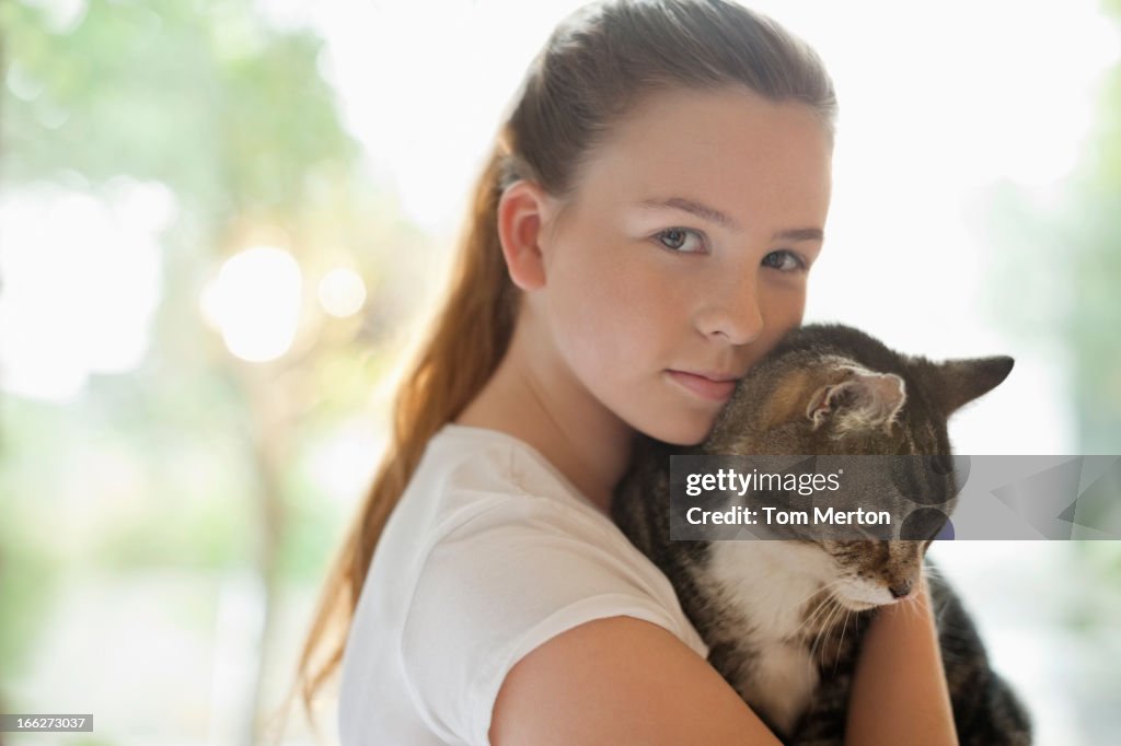 Girl holding cat indoors