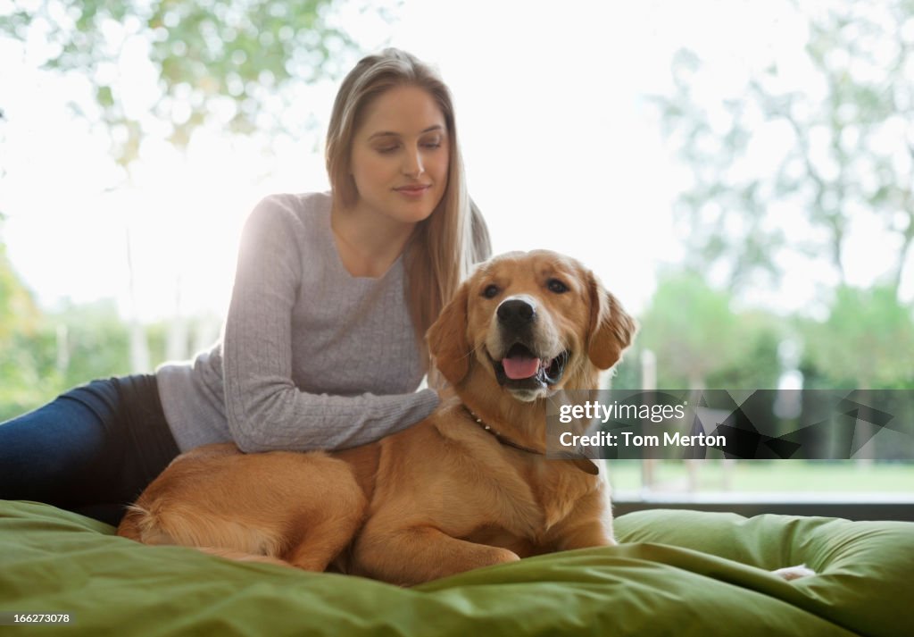 Woman petting dog on bed