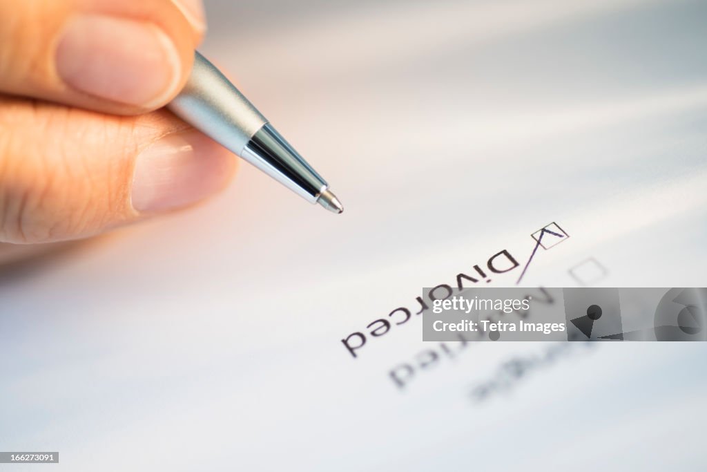 Close-up of hand filling out form