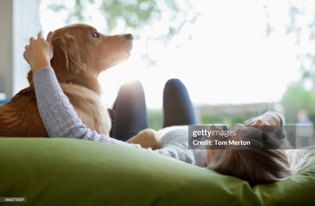 Woman petting dog on bed
