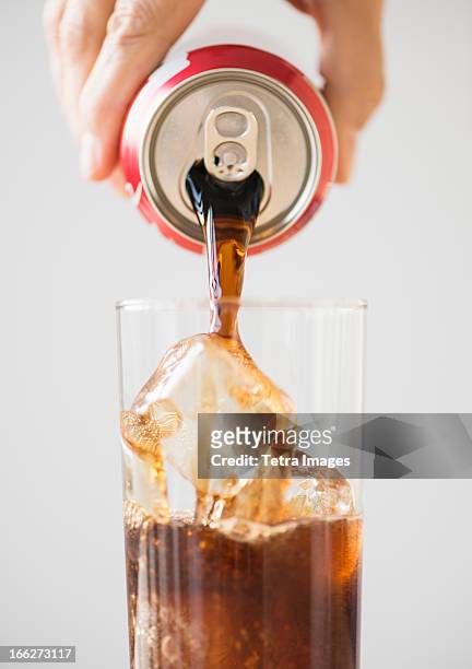 hand pouring cola - carbonation foto e immagini stock