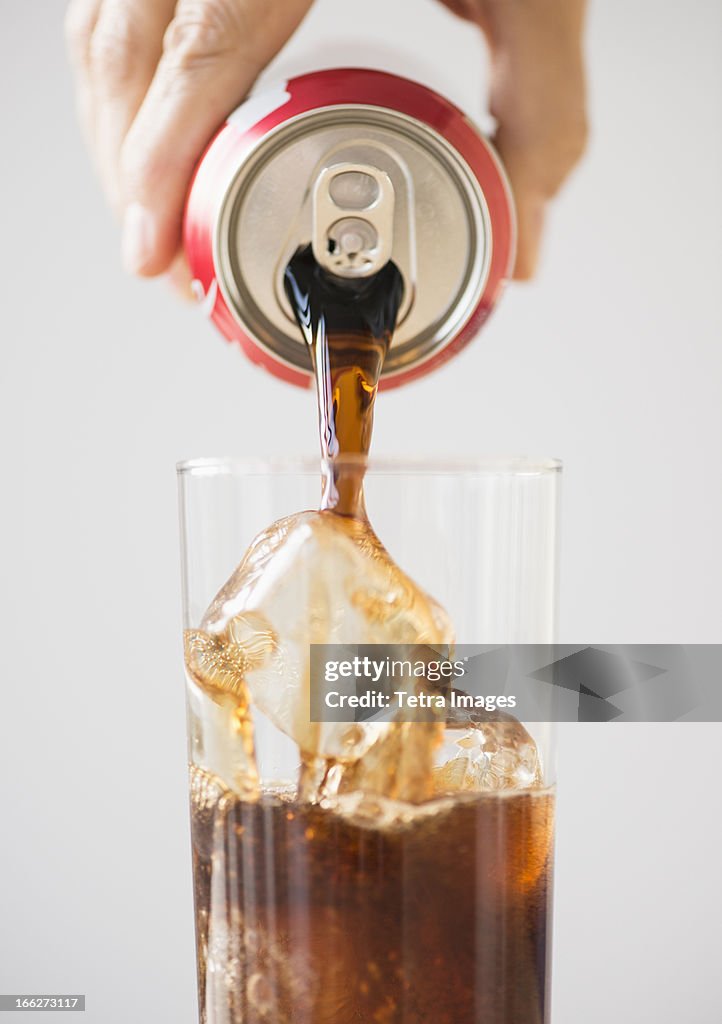 Hand pouring cola