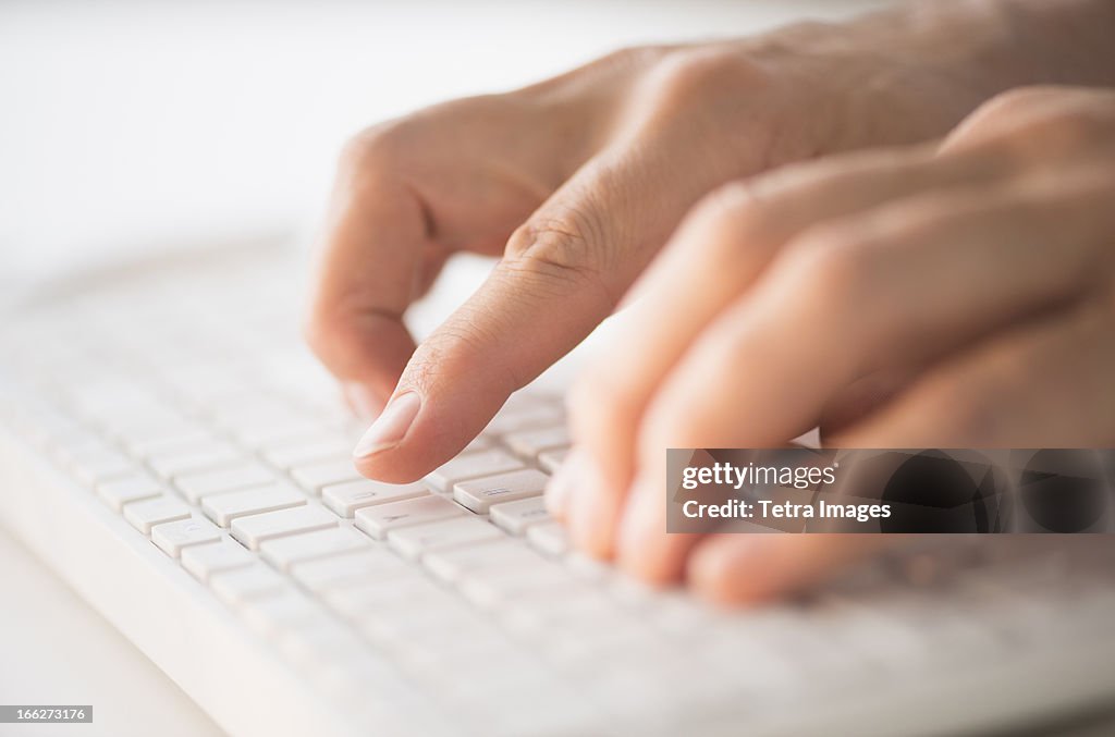 Close-up of hands typing on keyboard