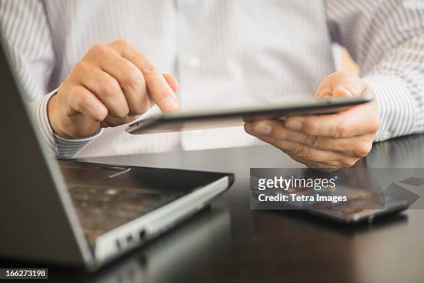 usa, new jersey, jersey city, man using tablet pc, laptop and smartphone - equipment stock pictures, royalty-free photos & images