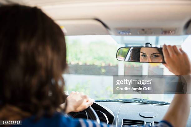 usa, new york state, rockaway beach, woman adjusting rear view mirror in car - 乗り物ミラー ストックフォトと画像