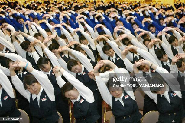 New employees of Japan's biggest supermarket and convenience store chain Ito Yokado Group stretch all together prior to a ceremony to celebrate their...