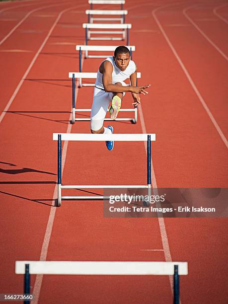 usa, california, fontana, boy (12-13) hurdling on running track - hurdle stock pictures, royalty-free photos & images