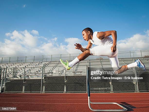 usa, california, fontana, boy (12-13) hurdling on running track - kids track and field stock pictures, royalty-free photos & images