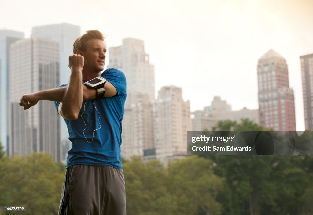 Runner stretching in urban park