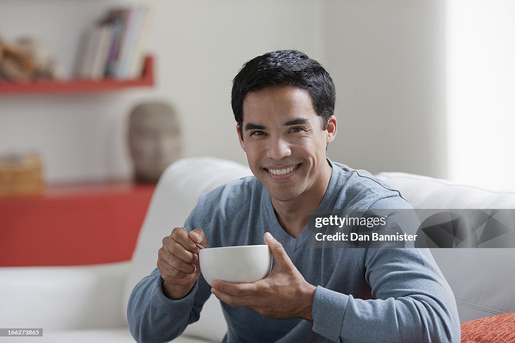 Portrait of man with bowl in living room