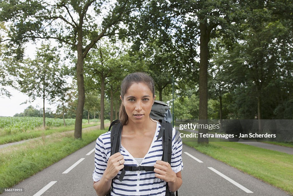 Netherlands, Hilvarenbeek, Portrait of young woman with backpack