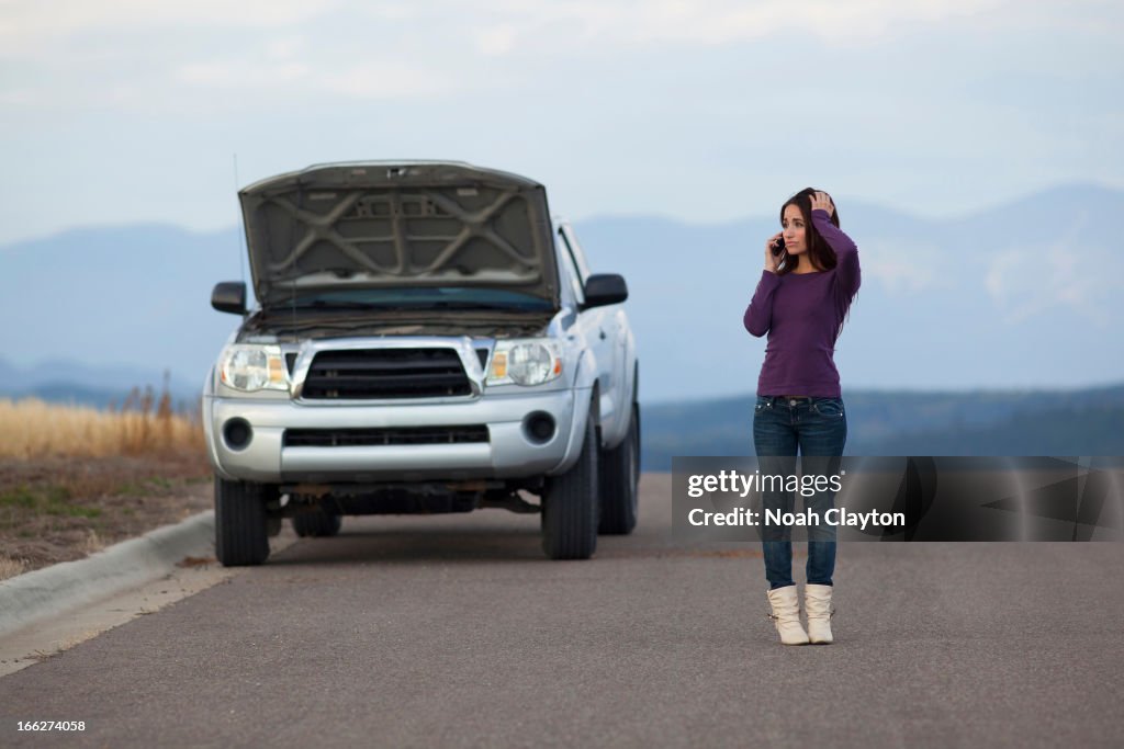 USA, Montana, Whitefish, Woman calling for assistance after vehicle breakdown