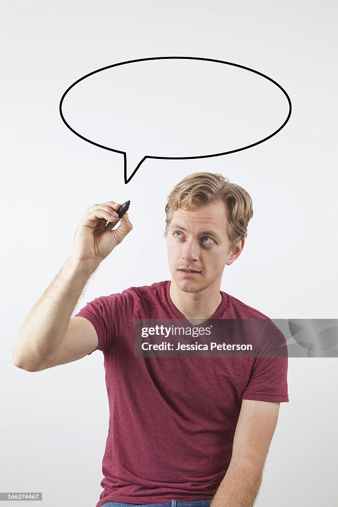 Portrait of man drawing speech bubble above his head