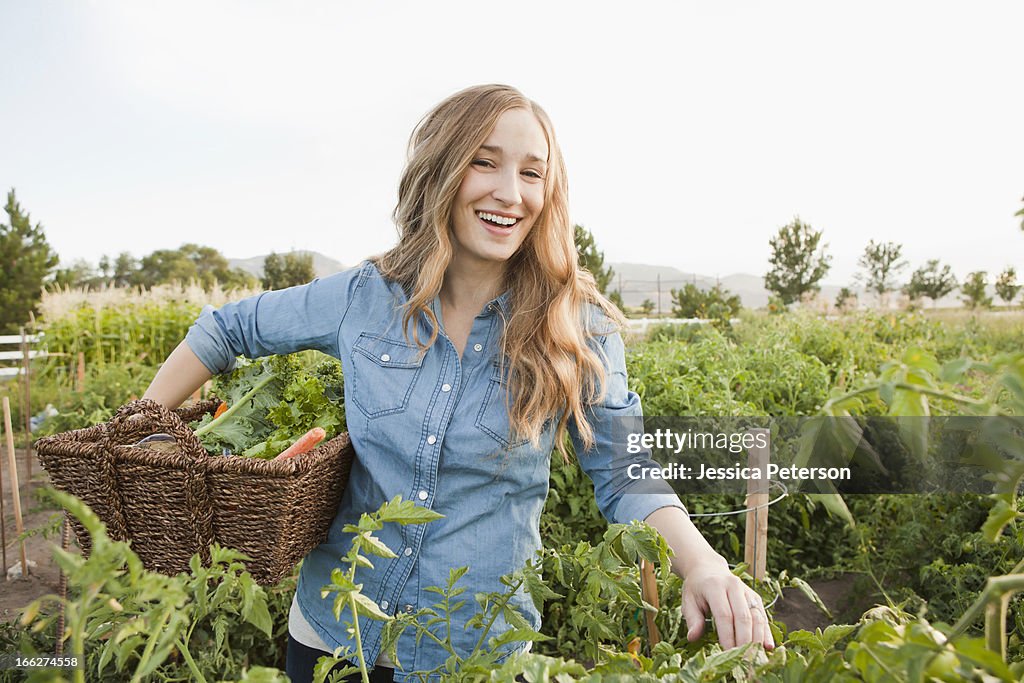 USA, Utah, Salt Lake City, Portrait of young woman harvesting vegetables