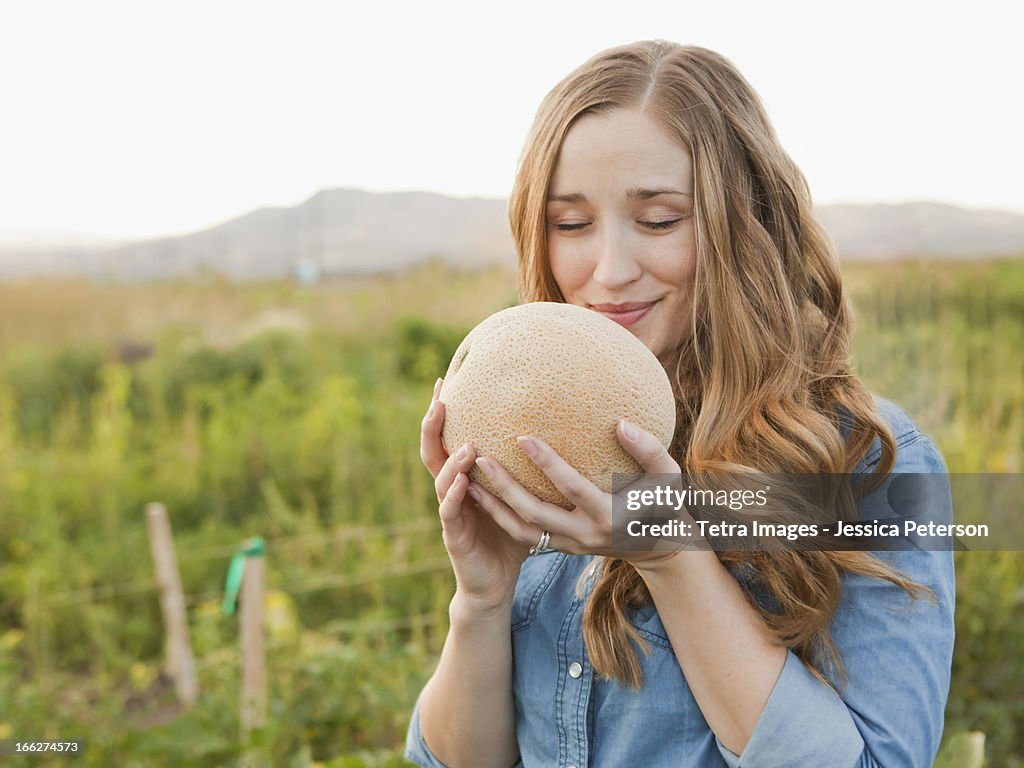 USA, Utah, Salt Lake City, Portrait of young woman holding cantaloupe