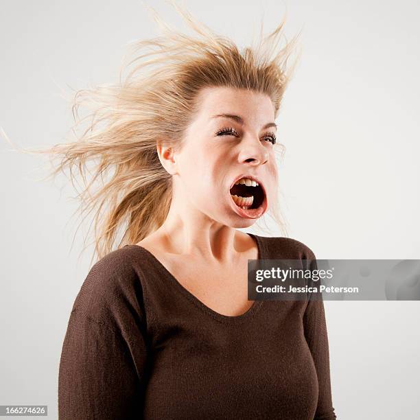 studio shot of woman with windblown mouth - making a face stock-fotos und bilder