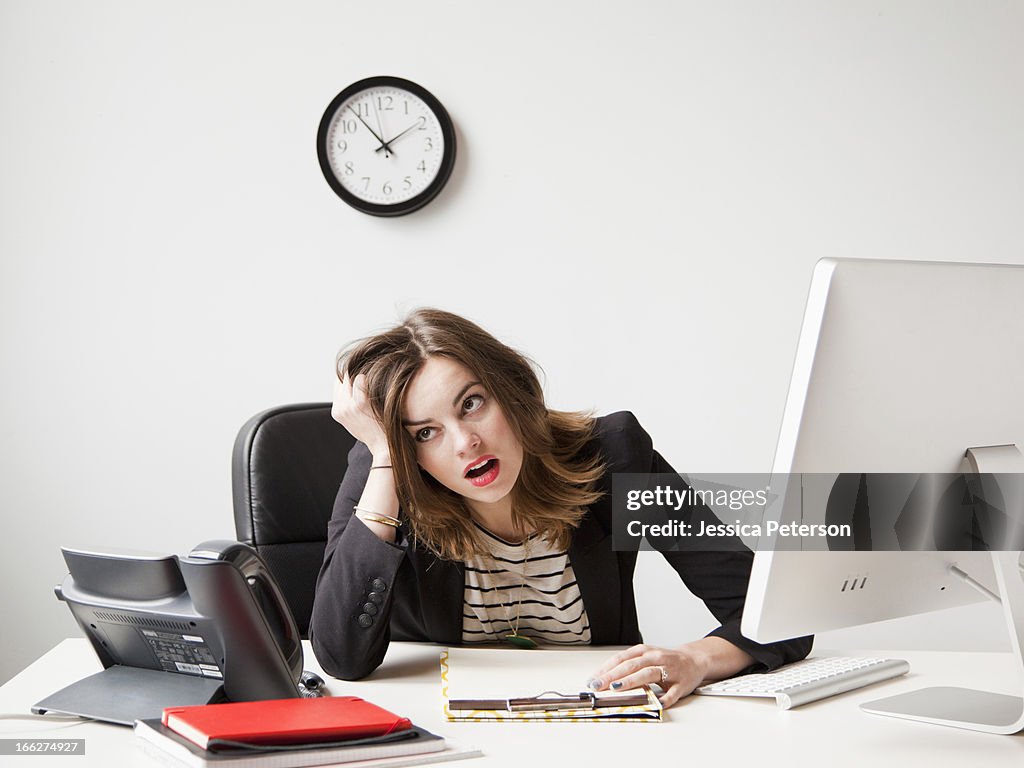 Studio shot of young woman working in office being under emotional stress