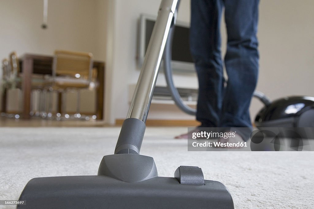 Germany, Baden-Württemberg, Stuttgart, Low Section of a Man Using a Vacuum Cleaner