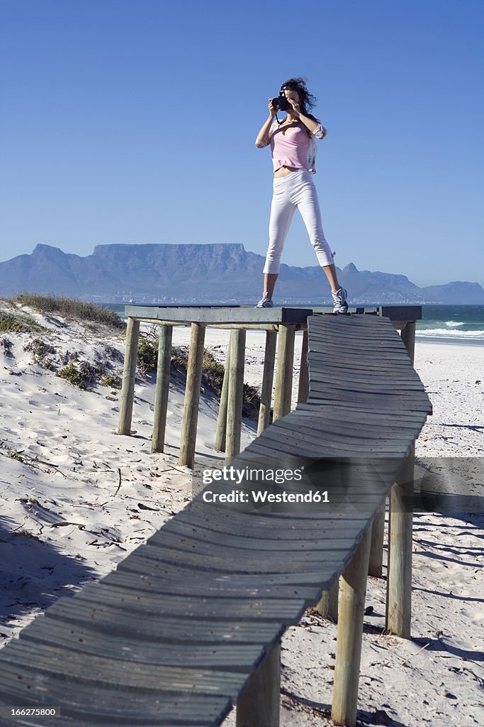 South Africa, Cape Town, Young woman taking photograph, portrait