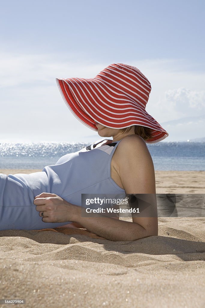 Woman lying on beach, side view