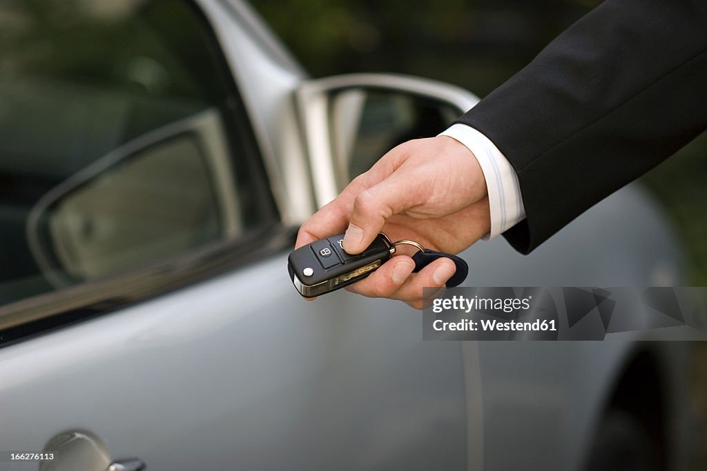 Person at car using remote control key, close-up