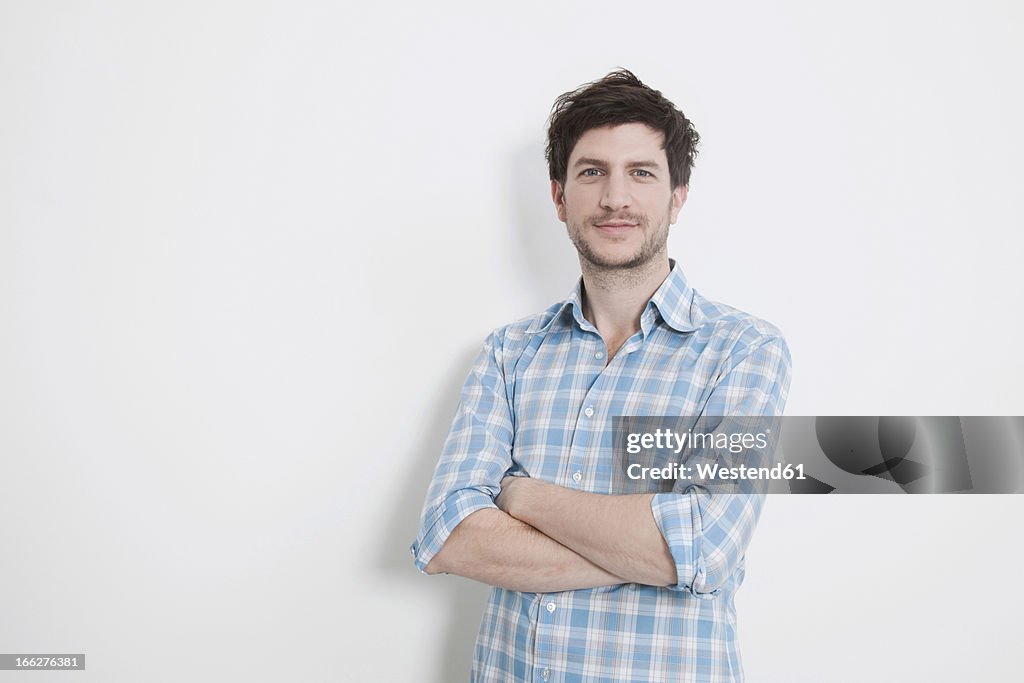 Man with arms crossed, smiling.