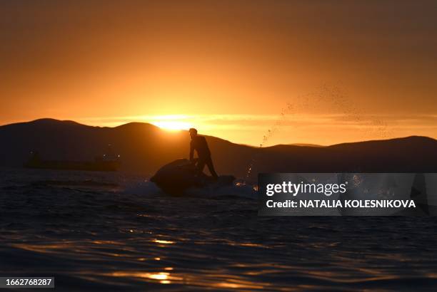 Local resident sails his jet ski at sunset near the Russian port city of Vladivostok, on September 13, 2023.