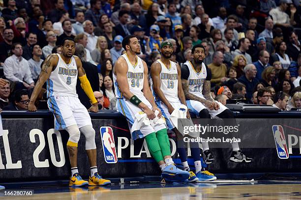 Andre Iguodala of the Denver Nuggets JaVale McGee Corey Brewer and Wilson Chandler sit on the scorers table waiting for the fourth quarter to start...