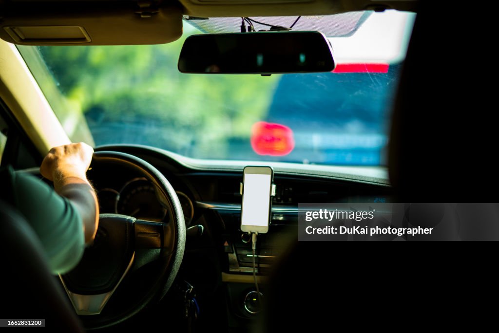 Man driving car with smartphone