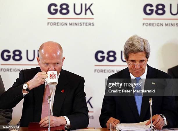 British Foreign Secretary William Hague takes a drink as he sits with US Secretary of State John Kerry for the first session at the Foreign Ministers...