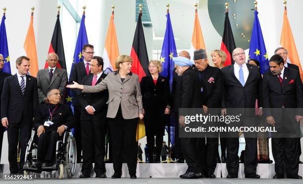 Indian Prime Minister Manmohan Singh and German Chancellor Angela Merkel arrive to pose with cabinet and delegation members at the Chancellery on...