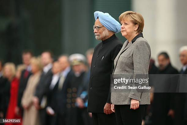 German Chancellor Angela Merkel and Indian Prime Minister Manmohan Singh listen to their nations' respective national anthems upon Singh's arrival at...