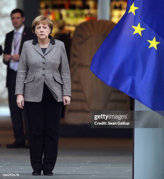 German Chancellor Angela Merkel stands at the entrance to the Chancellery next to a flag of the European Union shortly before the arrival of Indian...