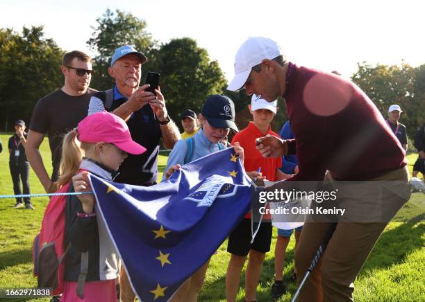 Rory McIlroy of Northern Ireland signs a Ryder Cup Europe flag for young fans during the Pro-Am prior to the Horizon Irish Open at The K Club on...